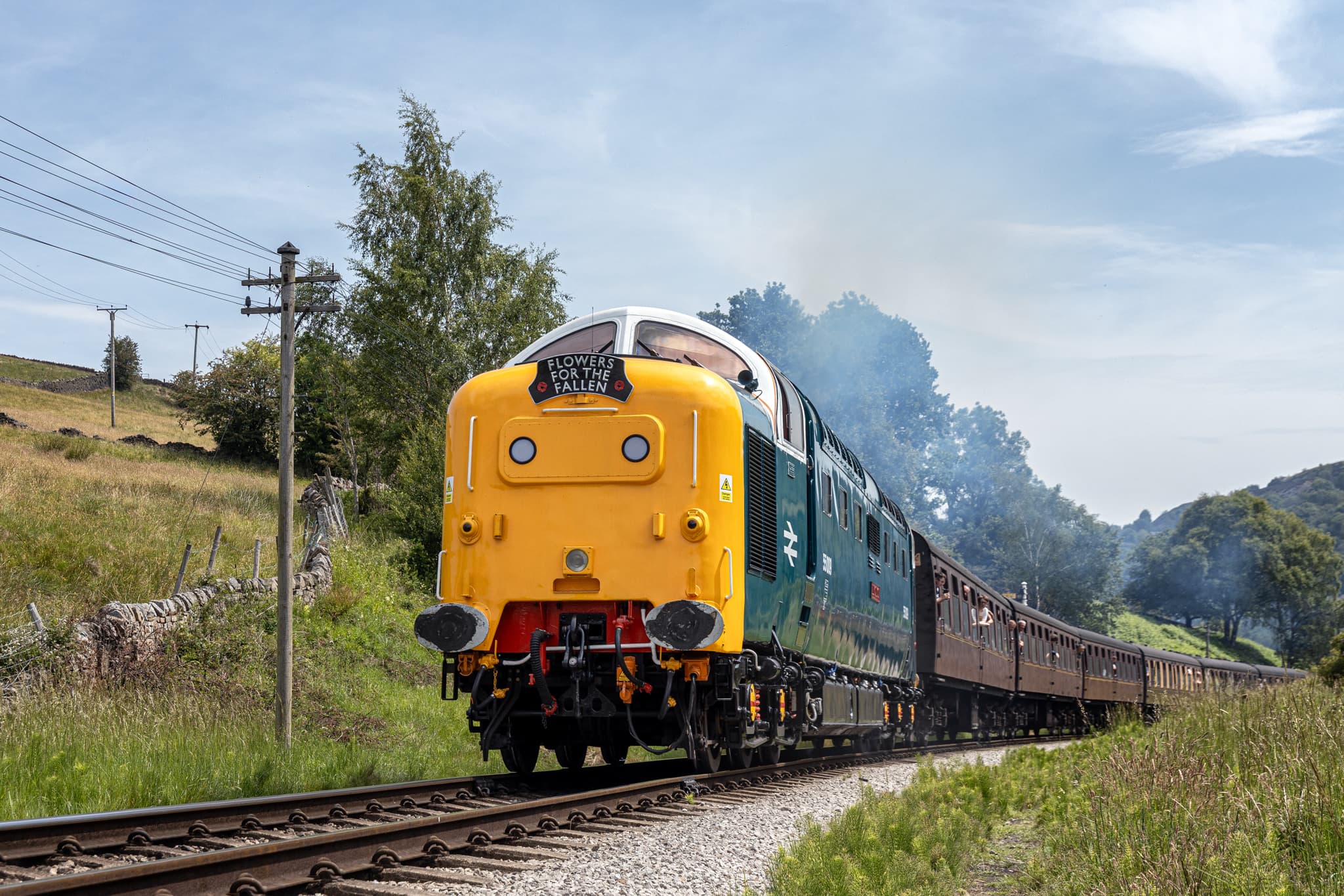 Historic green locomotive traveling through Yorkshire countryside