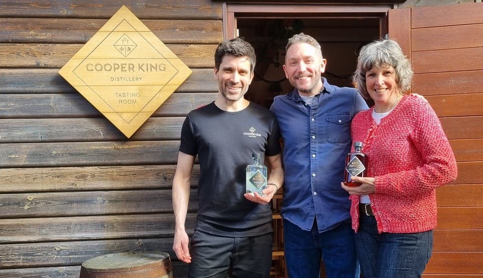 Three people smiling outside Cooper King Distillery tasting room