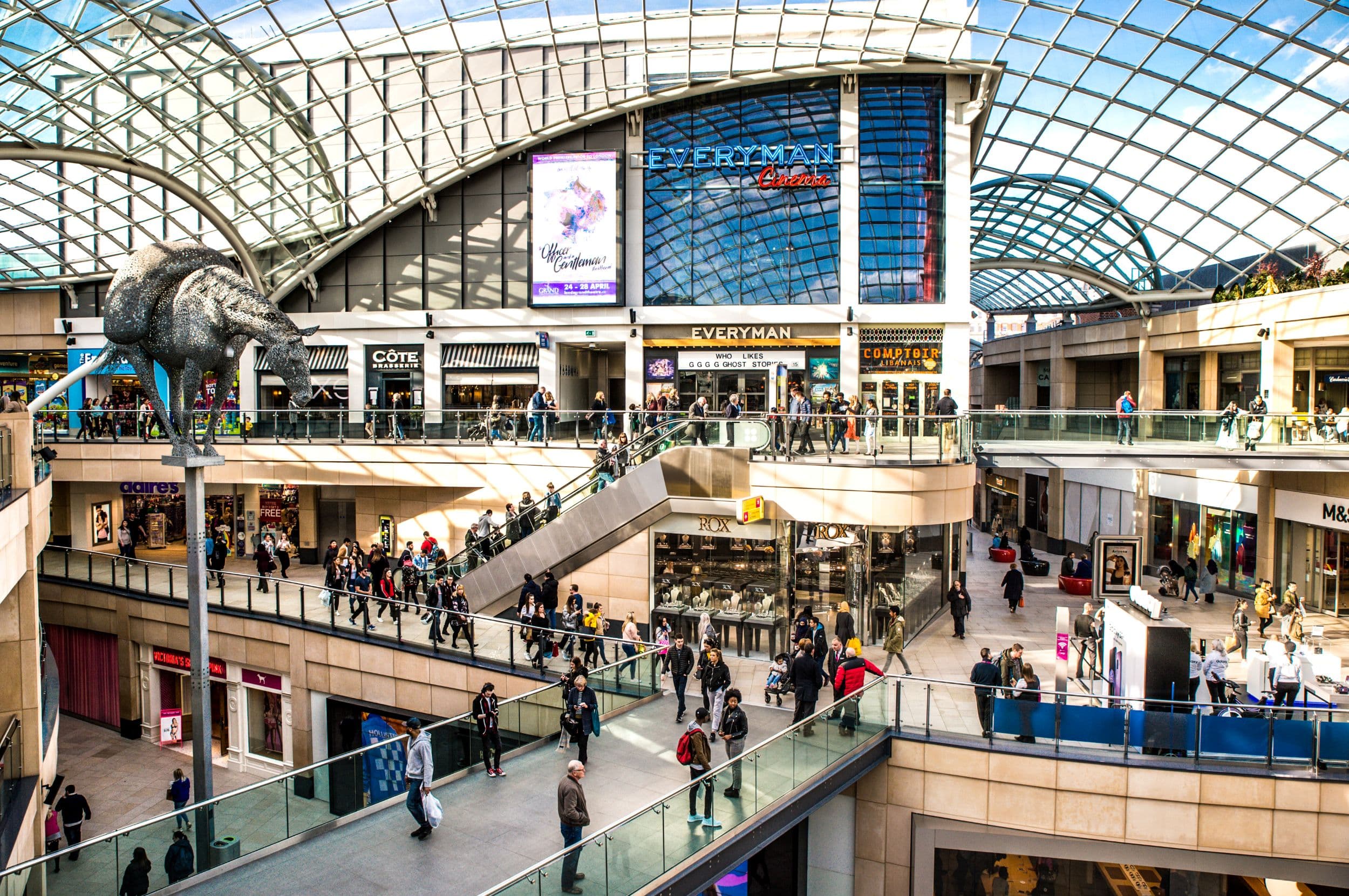 Modern shopping center with glass roof and large sculpture