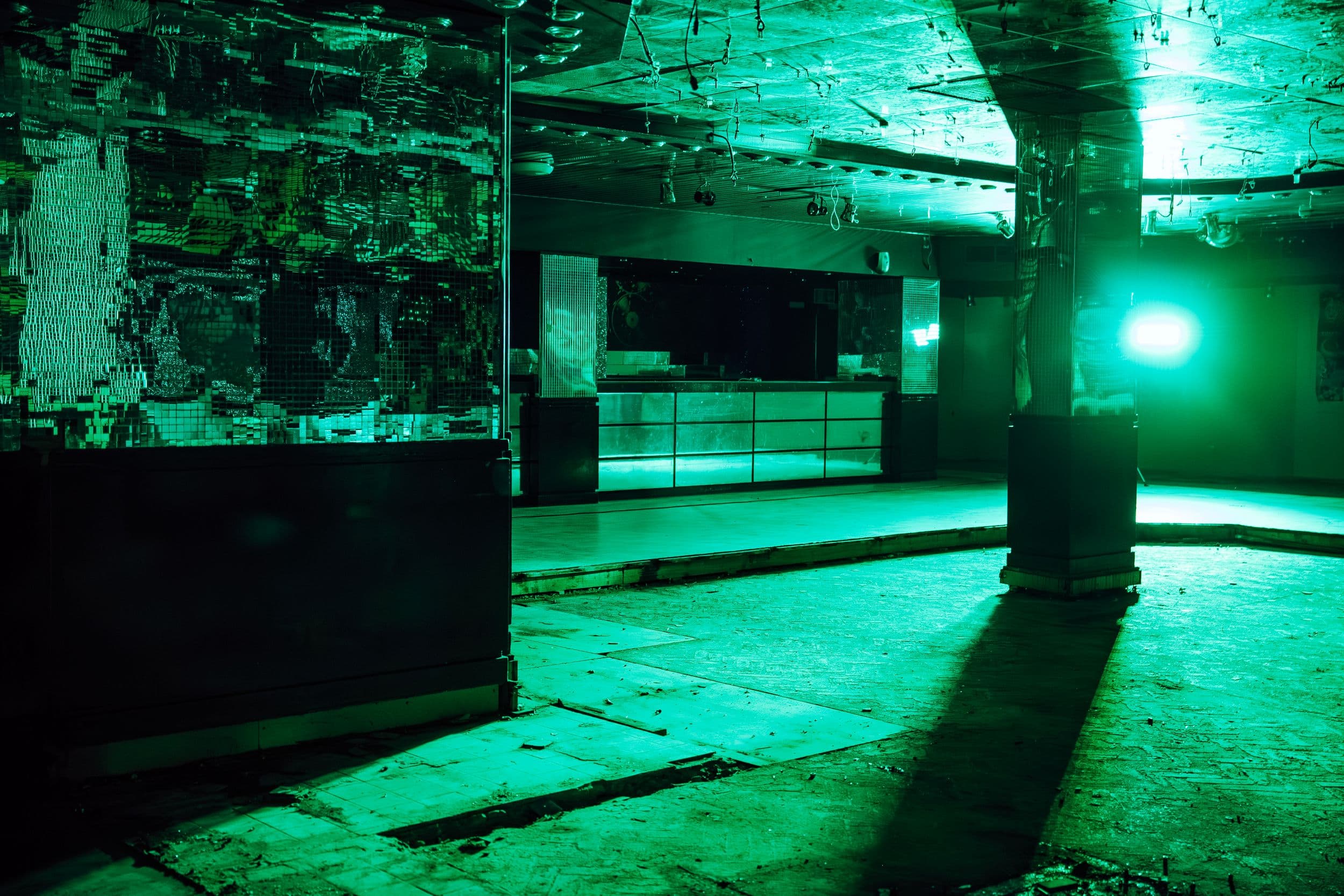Dimly lit nightclub interior with green lighting