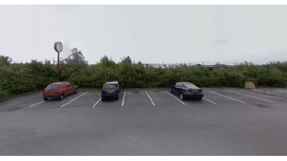 Pay & Display parking area in Birstall, Yorkshire, with three parked cars and overgrown greenery in the background.