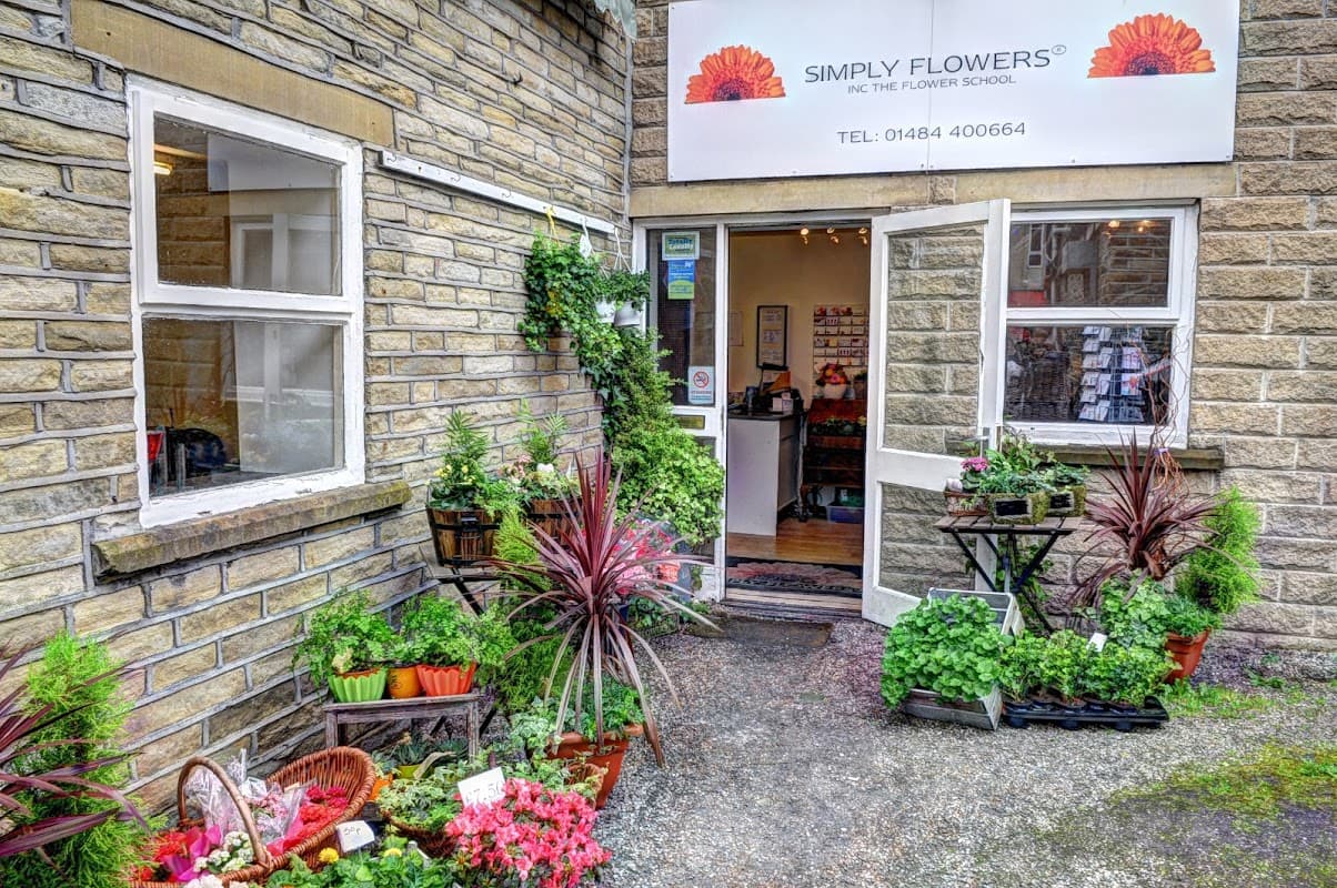 Charming flower shop entrance with potted plants, vibrant flowers, and a welcoming open door in Brighouse, Yorkshire.