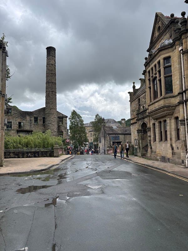GeniePoint Charging Station in Chiserley, Yorkshire, with historic buildings and a cloudy sky in the background.