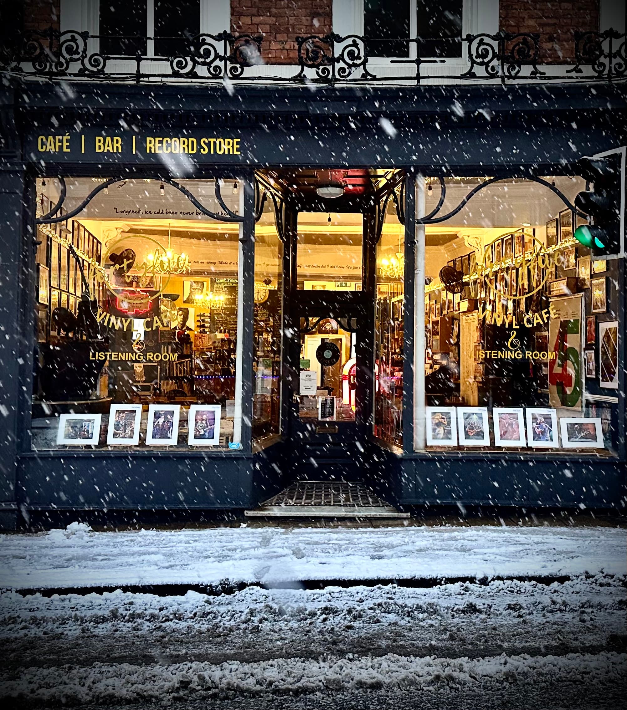 Vinyl café storefront with large windows, plants, and a sign announcing "NOW OPEN" in York, Yorkshire.