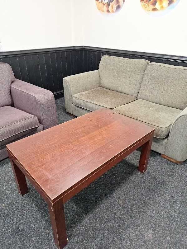 Two sofas in a cozy seating area with a wooden coffee table on a dark carpet.