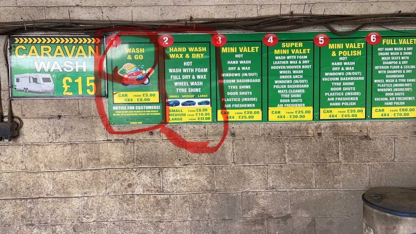 Signboard displaying car wash services and prices, including options for hand wash, mini valet, and full valet.