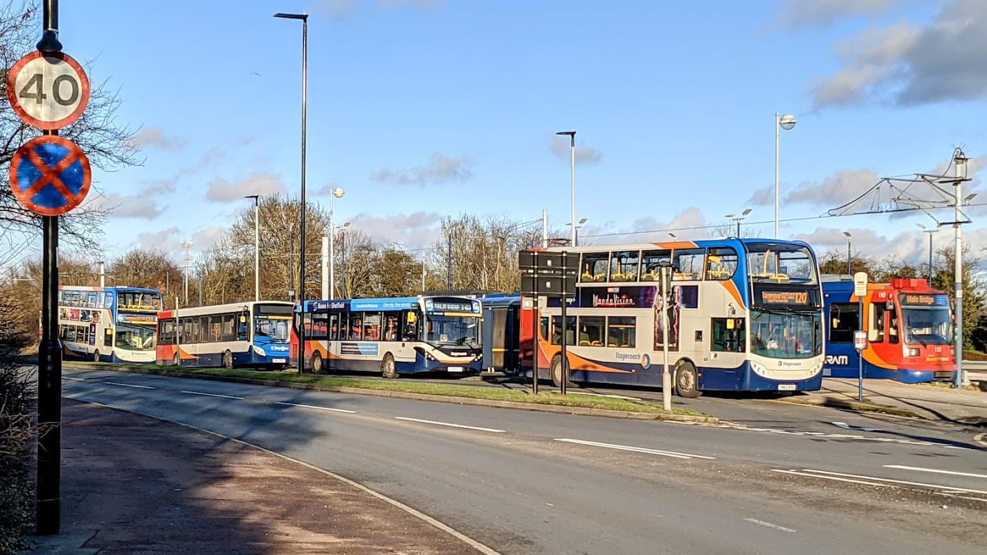 Buses lined up along a road with a 40 mph speed limit sign and a no parking sign in Mosborough, Yorkshire.