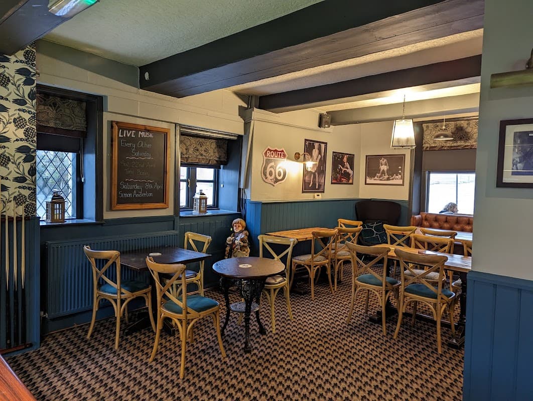 Cozy bar interior with wooden tables, chairs, a chalkboard menu, and vintage decor in Riddlesden, Yorkshire.