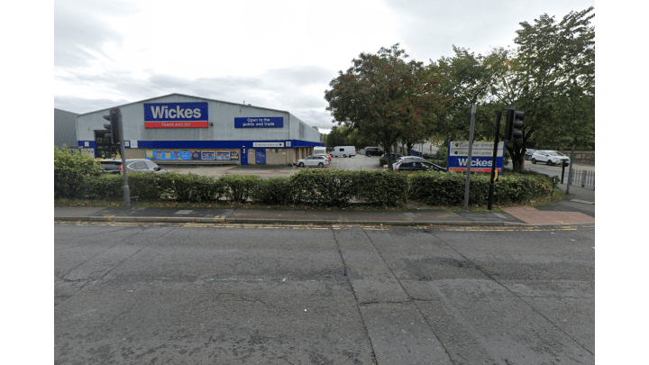 Pay & Display parking area near Wickes store in Thornhill, Yorkshire, with cars and trees lining the street.