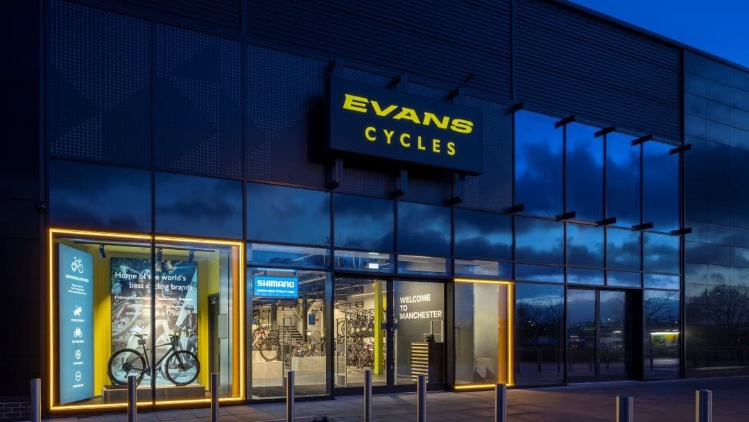 Brightly lit storefront of Evans Cycles, featuring bike displays and welcoming signage in York, Yorkshire.