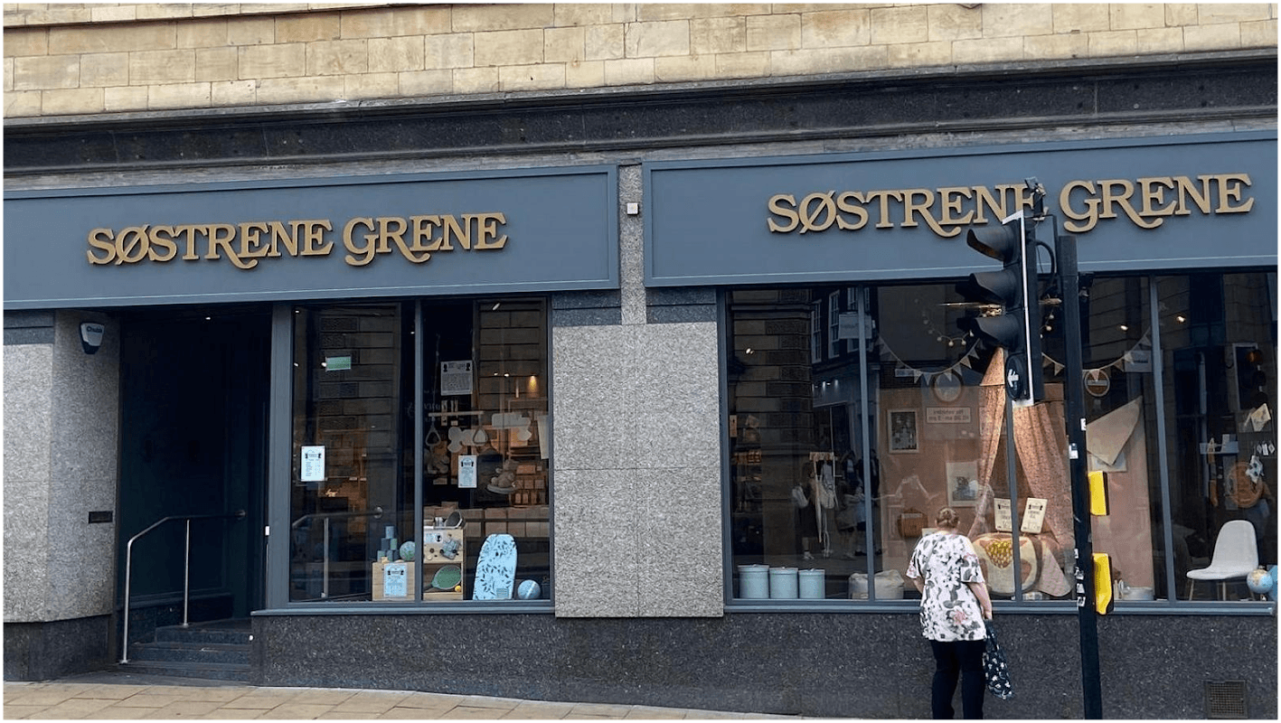 Two large storefronts of Sรธstrene Grene with elegant signage, showcasing home decor and furniture items.
