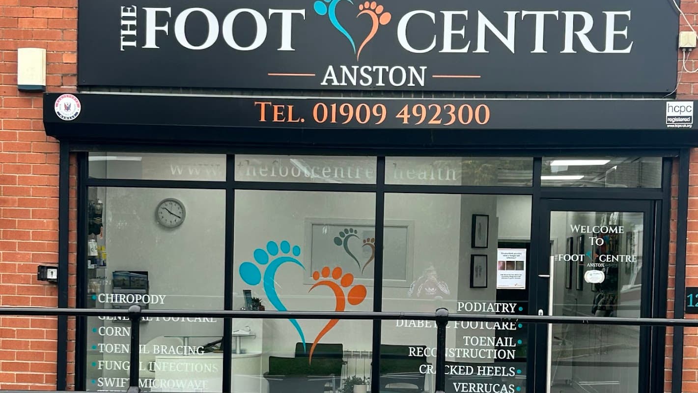 Sign for "THE FOOT CENTRE ANSTON" with colorful footprints and contact details, showcasing a welcoming entrance.