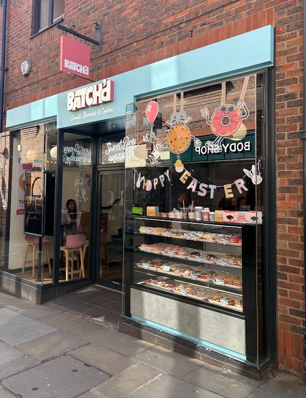 Bright storefront of Batch'd bakery in York, featuring colorful pastries and a festive "Happy Easter" display.