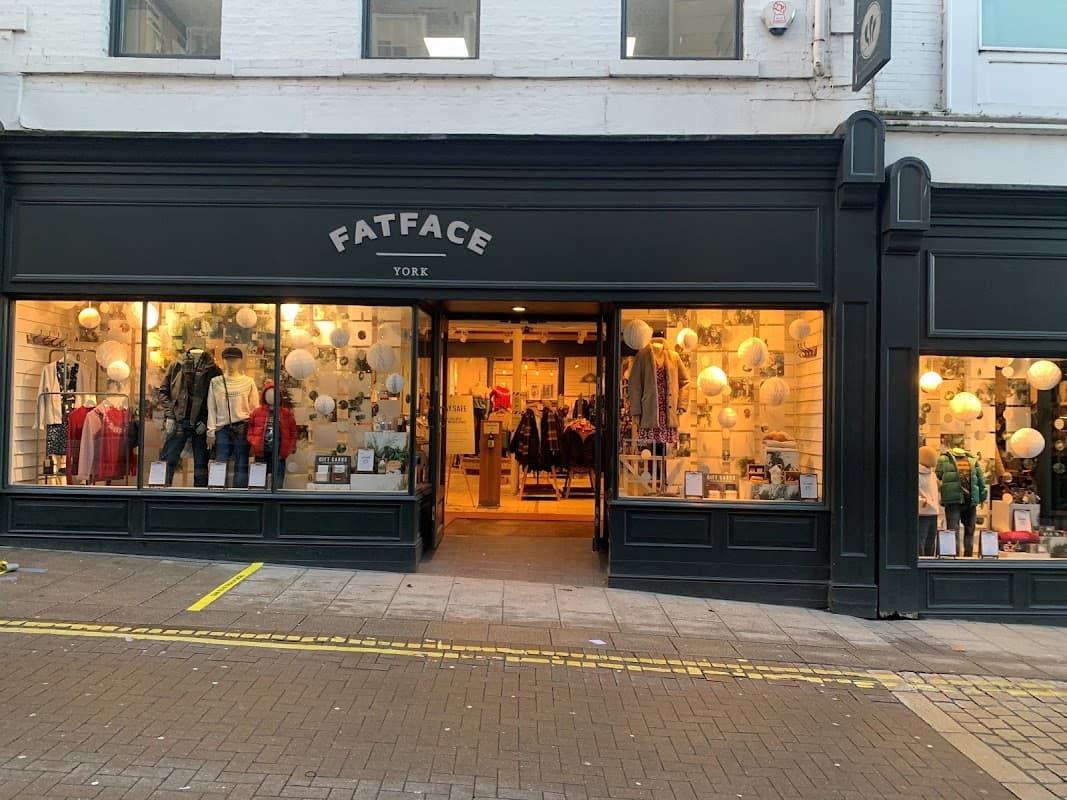 FatFace storefront in York, featuring clothing displays, warm lighting, and a welcoming entrance.