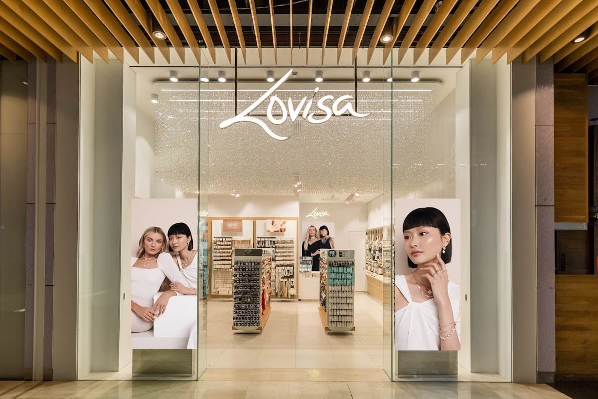 Jewellery store entrance with large glass doors, bright displays, and promotional images of models showcasing accessories.