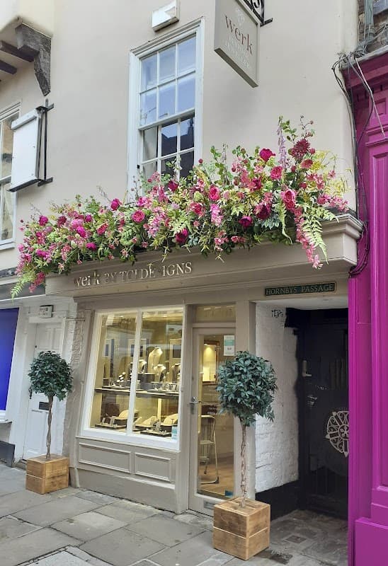 Jewellers shop "Werk" in York with floral display, two potted trees, and elegant window showcasing jewelry.