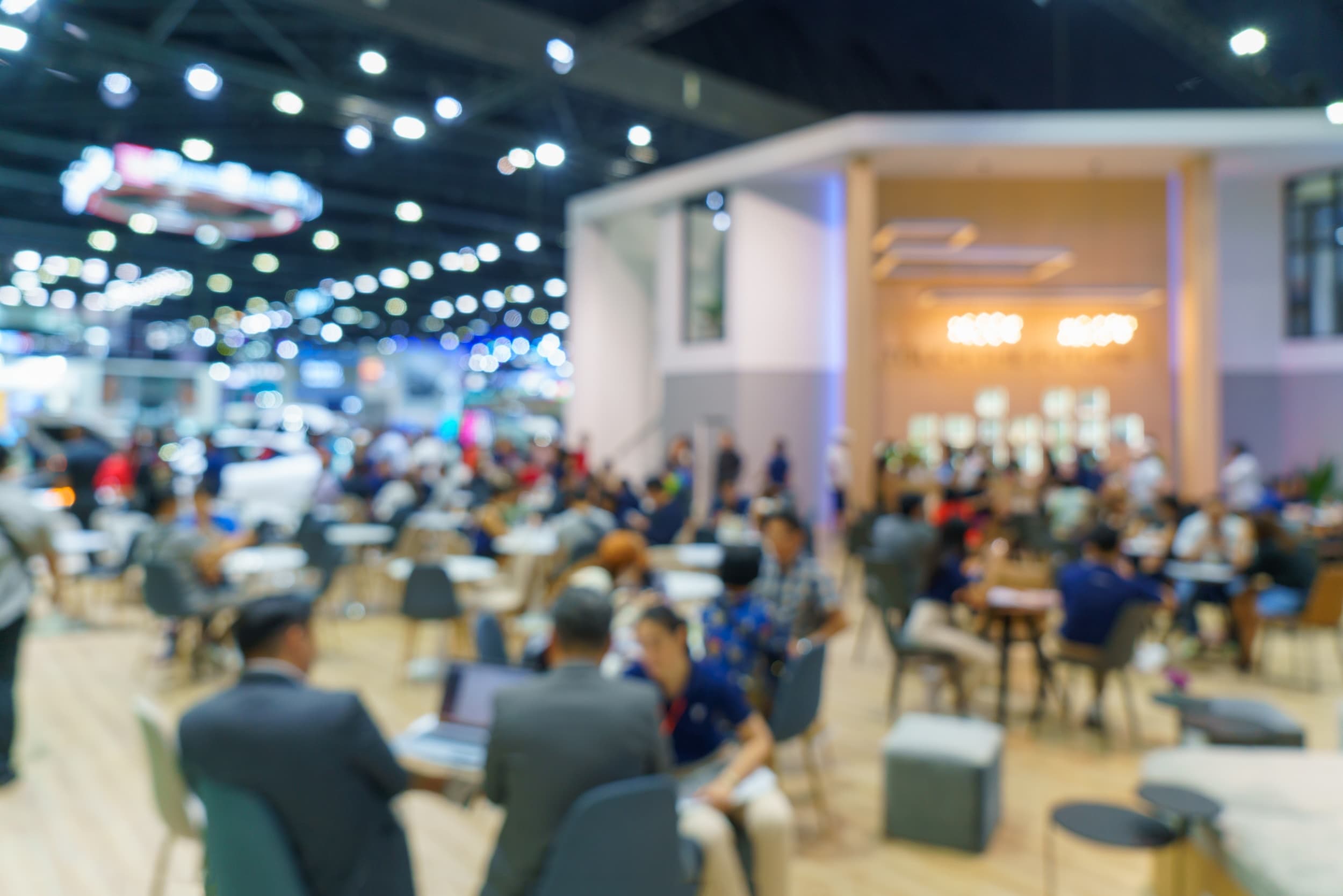 Busy indoor market with people at tables under bright lights