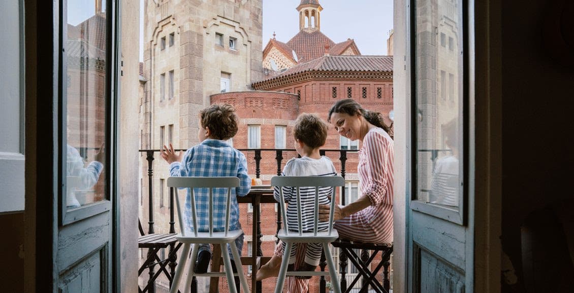 Family on balcony overlooking historic brick buildings