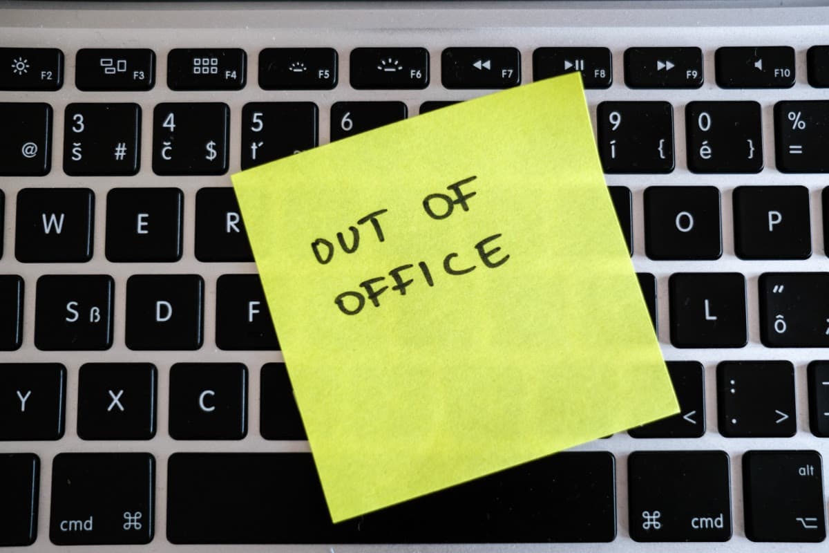 Yellow sticky note with 'Out of Office' on a laptop keyboard
