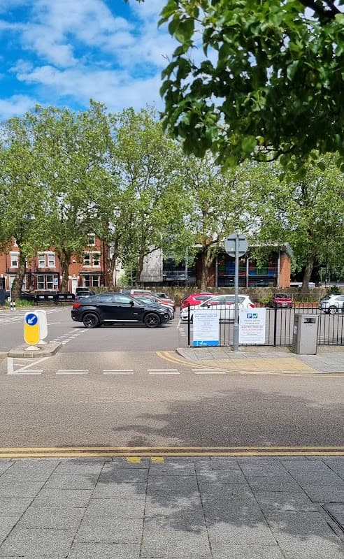 Pay & Display car park entrance with vehicles, trees, and signage in Doncaster, Yorkshire under a blue sky.