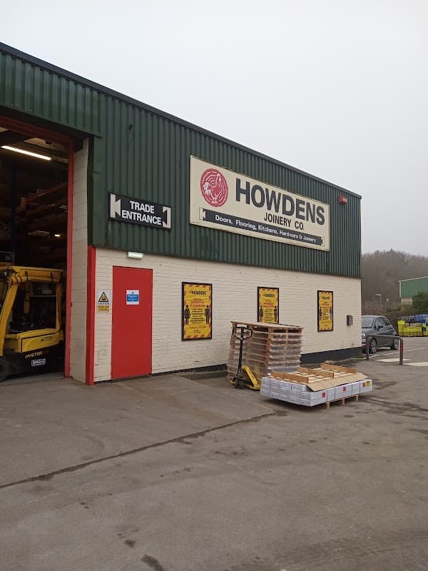 Howdens Joinery Co. building exterior with a trade entrance, signage, and pallets outside in Farsley, Yorkshire.