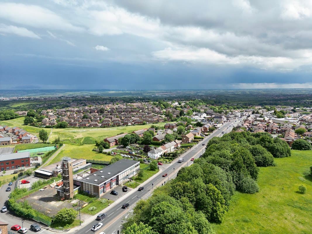 Aerial view of Manor, Yorkshire, showing residential areas, a Pay & Display car park, and green fields under a cloudy sky.