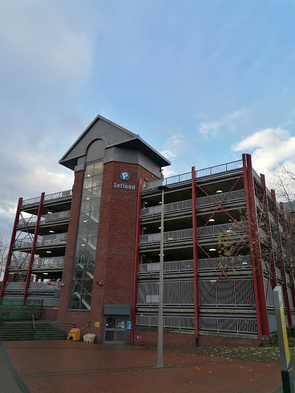 Zetland Multi Storey Car Park with red steel framework, multiple levels, and a clear blue sky in Middlesbrough.