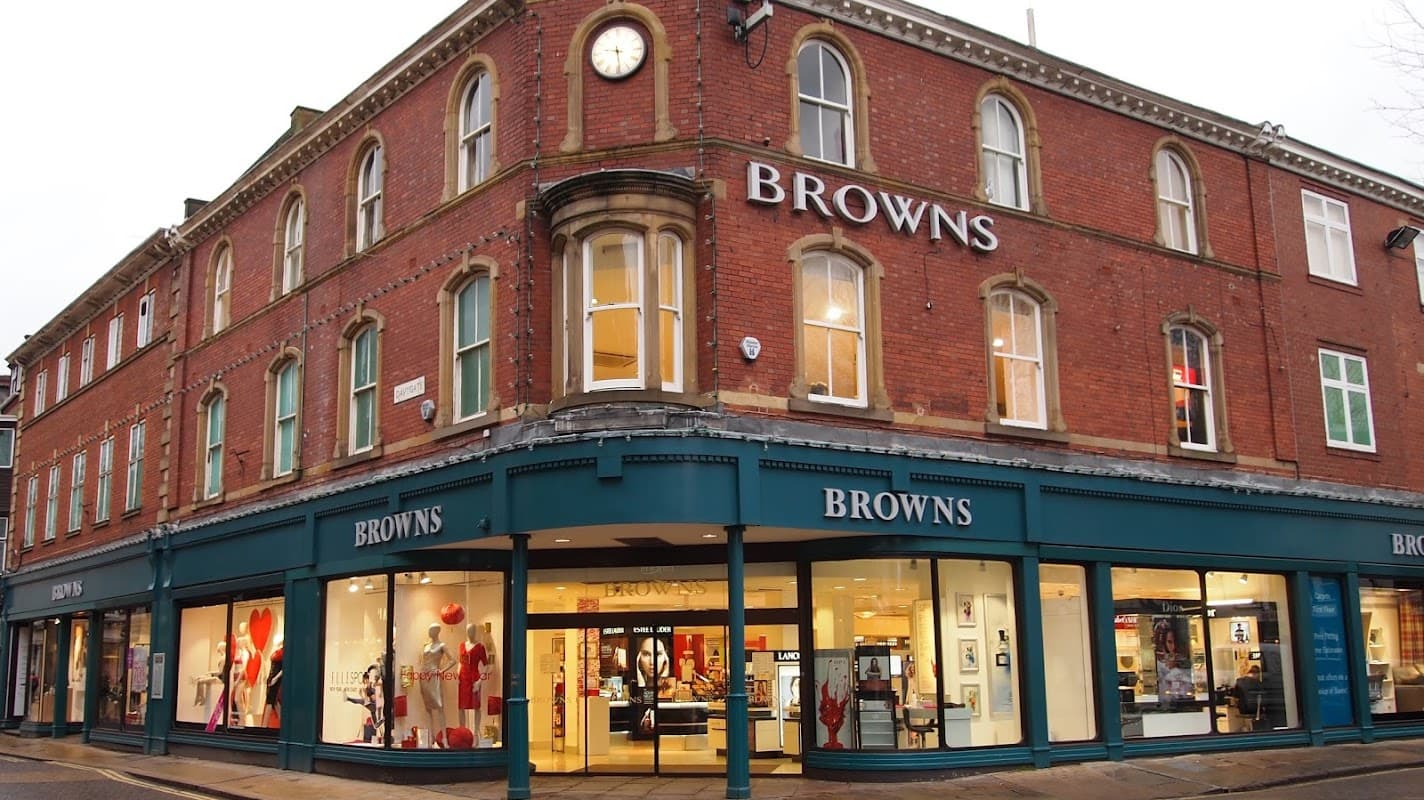Browns York storefront featuring large windows, red brick exterior, and prominent clock above the entrance.