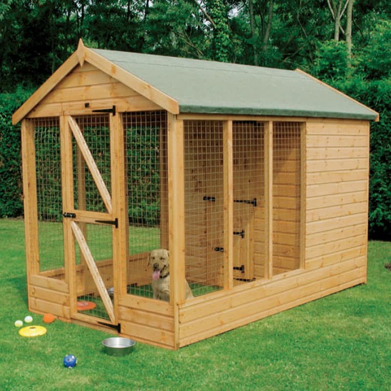 Traditional wooden dog kennel with a 6-foot run, featuring a sloped green roof, wooden panels, a secure mesh door, and a dog inside, set on grass with colorful toys.