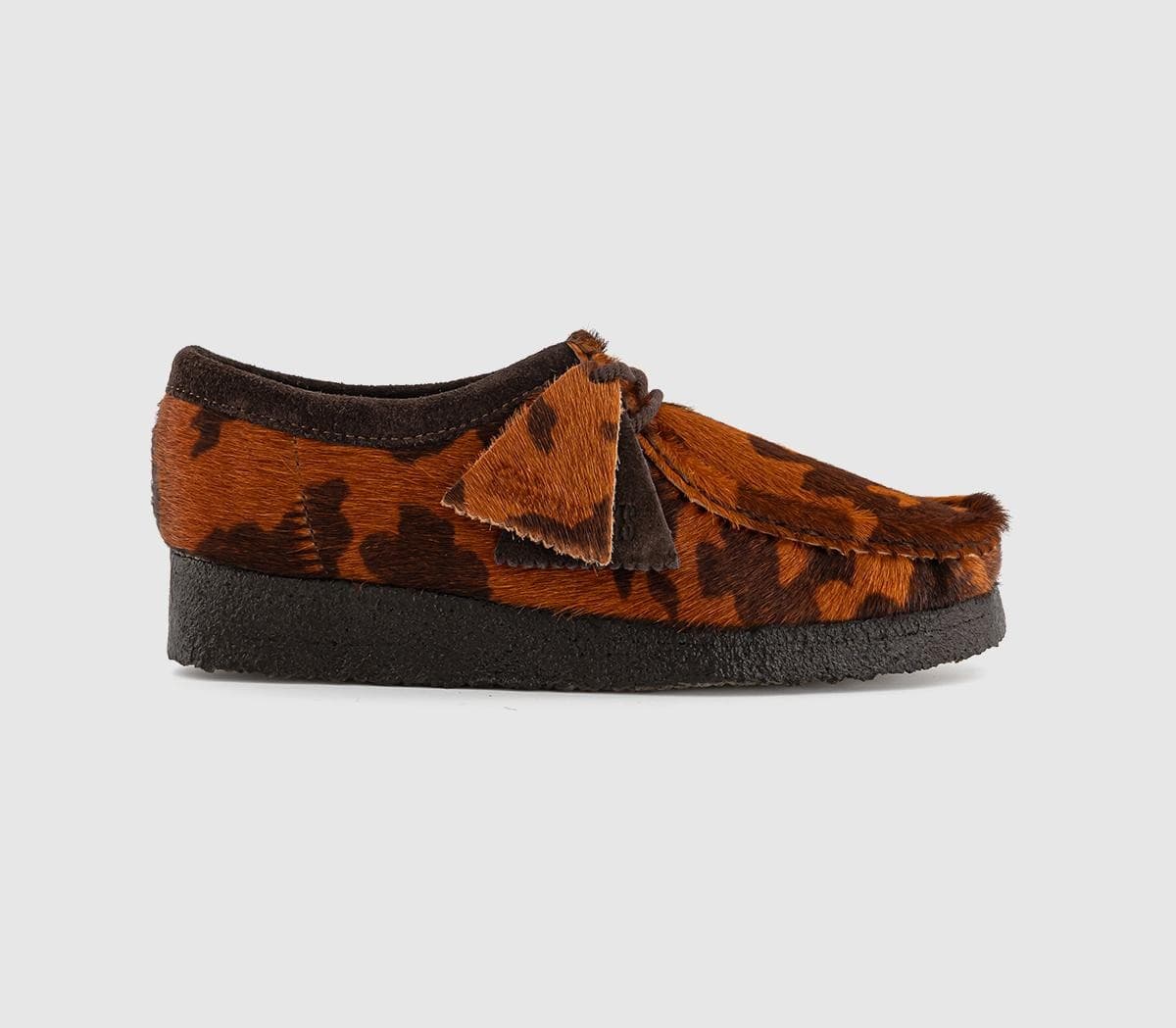 Brown cow print suede women's Wallabees by Clarks Originals, featuring a soft fur texture, dark brown accents, and a 3-inch crepe sole.