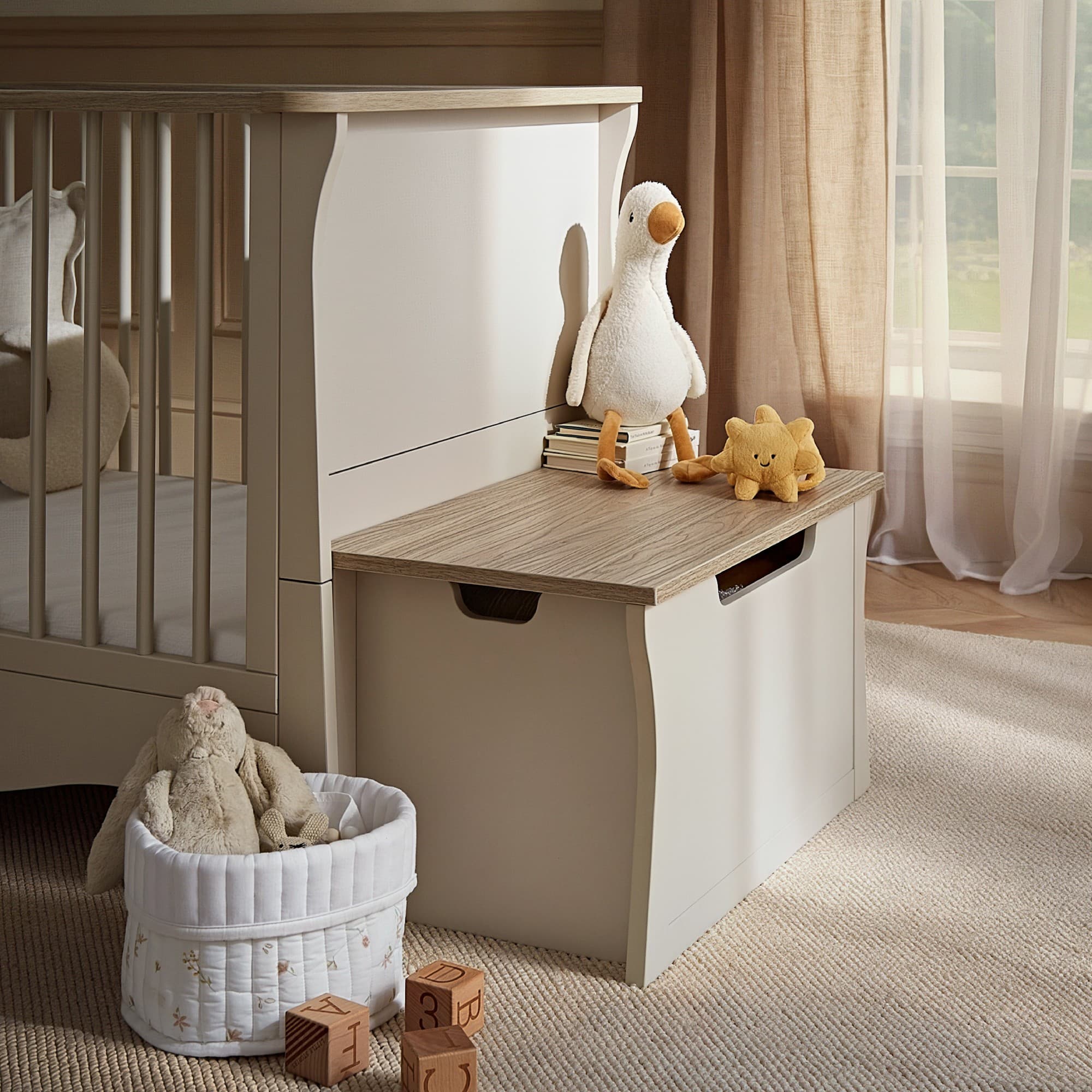 Clara Storage Box in cashmere and ash features a smooth, light beige exterior with a wood-grain top, designed for stylish organization in a nursery setting.