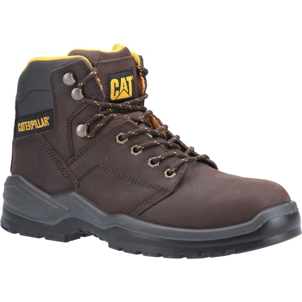 Brown leather safety boot with yellow accents, featuring a padded collar, metal eyelets, and a rugged sole for traction, designed for durability and protection.