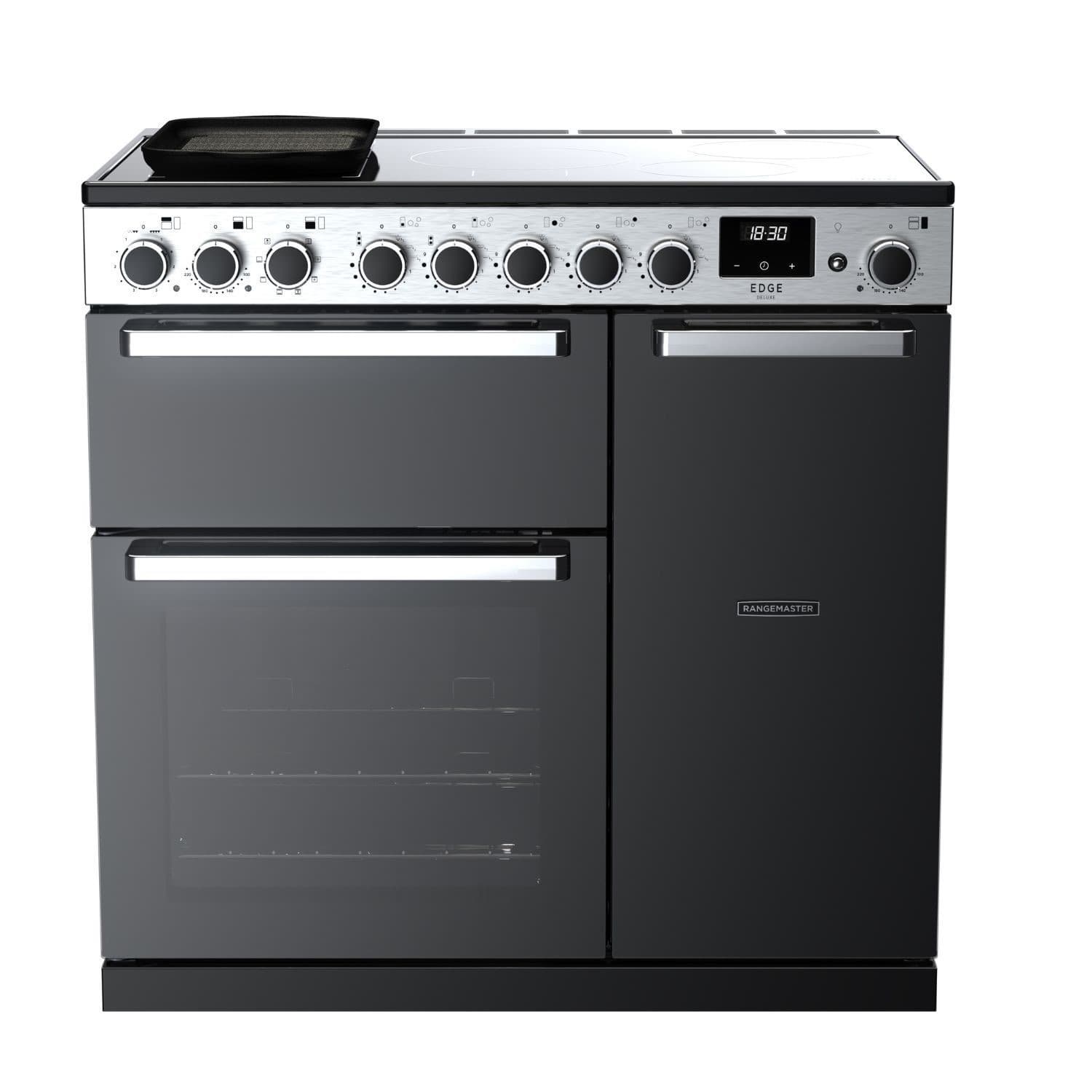 Rangemaster Edge Deluxe 90cm induction range cooker in black glass features a sleek design, five control knobs, a digital display, and two spacious ovens with stainless steel accents.
