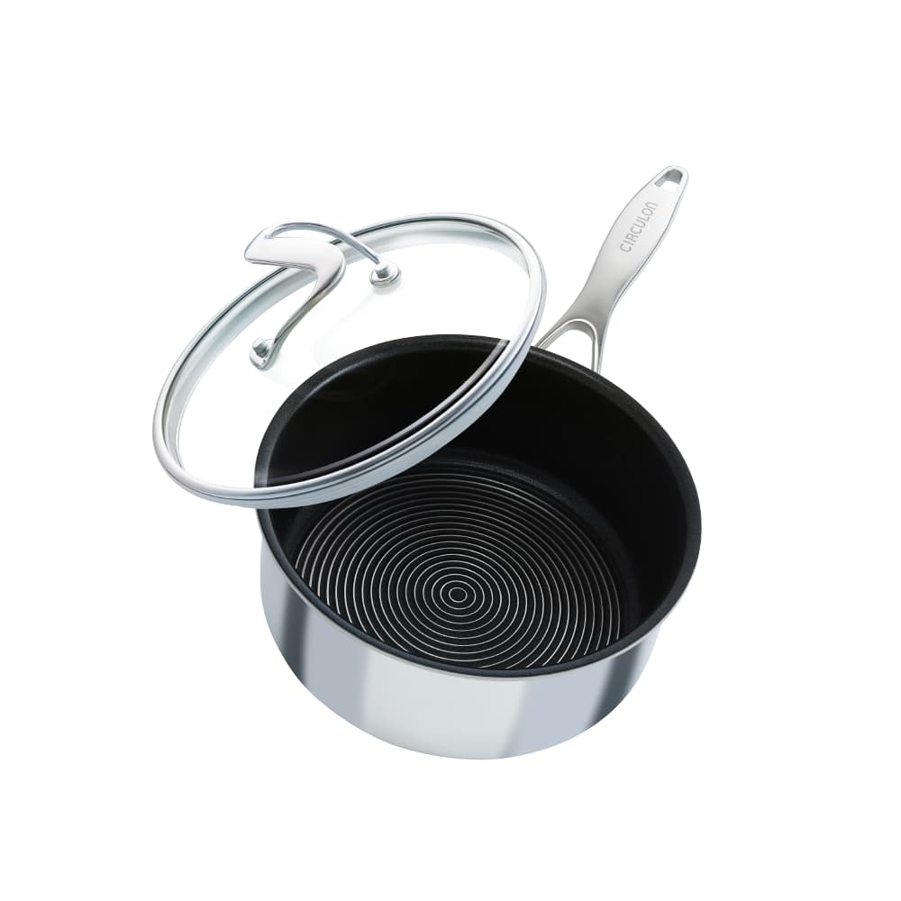 Polished stainless steel saucepan with a black non-stick interior and a glass lid, featuring a sleek handle and concentric circle design, available in three sizes.