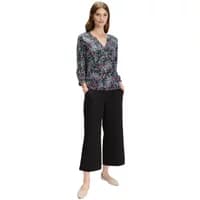 Floral print blouse with V-neck and long sleeves, paired with black wide-leg pants.