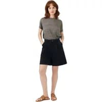 Black high-waisted shorts with side pockets, worn by a model in a gray top and brown sandals.
