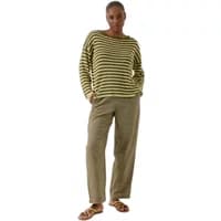 Green and black striped Artlove Meonea sweater, long sleeves, relaxed fit, worn by a model with hands in pockets.