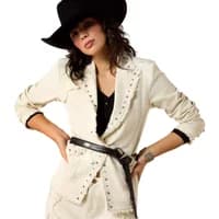 Cream women's blazer with studded lapels, black belt, and rolled sleeves, worn with a black cowboy hat.