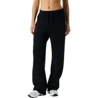 Black women's joggers by Björn Borg Studio, featuring a drawstring waist and relaxed fit, paired with white sneakers.