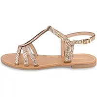 Women's gold strappy sandals with ankle buckle and flat sole, featuring metallic accents and open toe design.