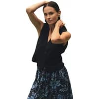 Black women's suit waistcoat by Greenpoint, sleeveless with a V-neck, paired with a floral skirt.