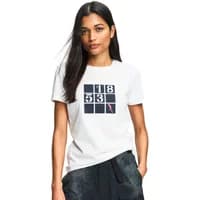 White women's T-shirt by Aigle with black square grid design and pink accent, worn by a model with dark hair.