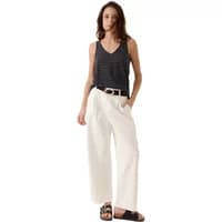 Black sleeveless tank top with a V-neck and subtle stripe pattern, worn with white wide-leg pants and black sandals.