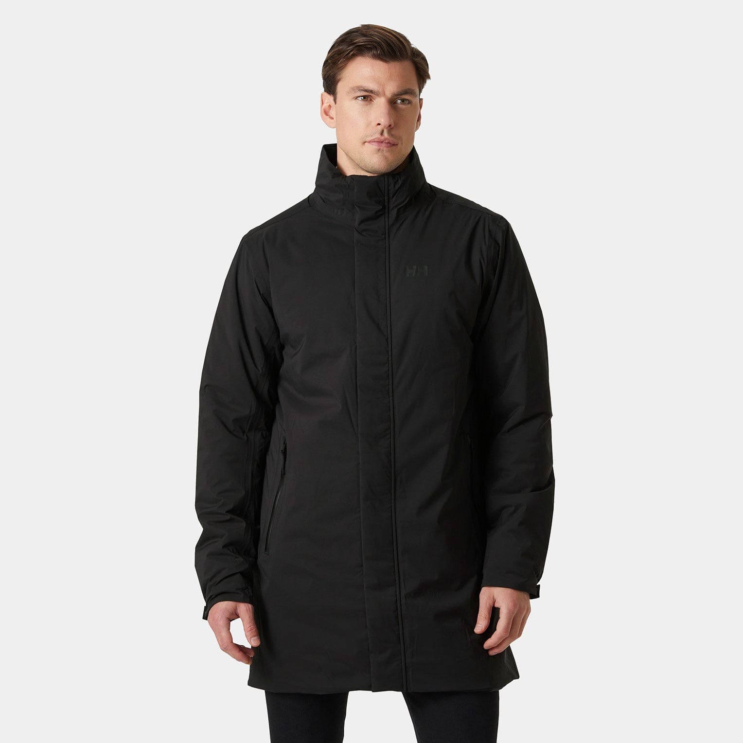 Long black waterproof jacket by Helly Hansen, featuring a high collar, zippered front, and side pockets, made from durable material for protection against the elements.