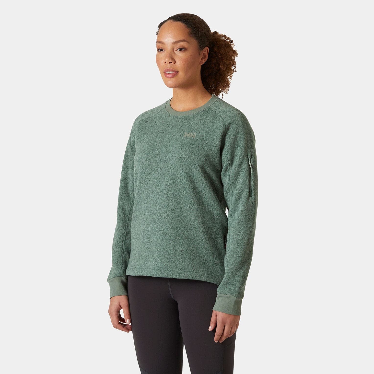 Green Helly Hansen Varde women's sweatshirt made of soft, textured fabric, featuring a crew neckline, ribbed cuffs, and a subtle logo on the chest.