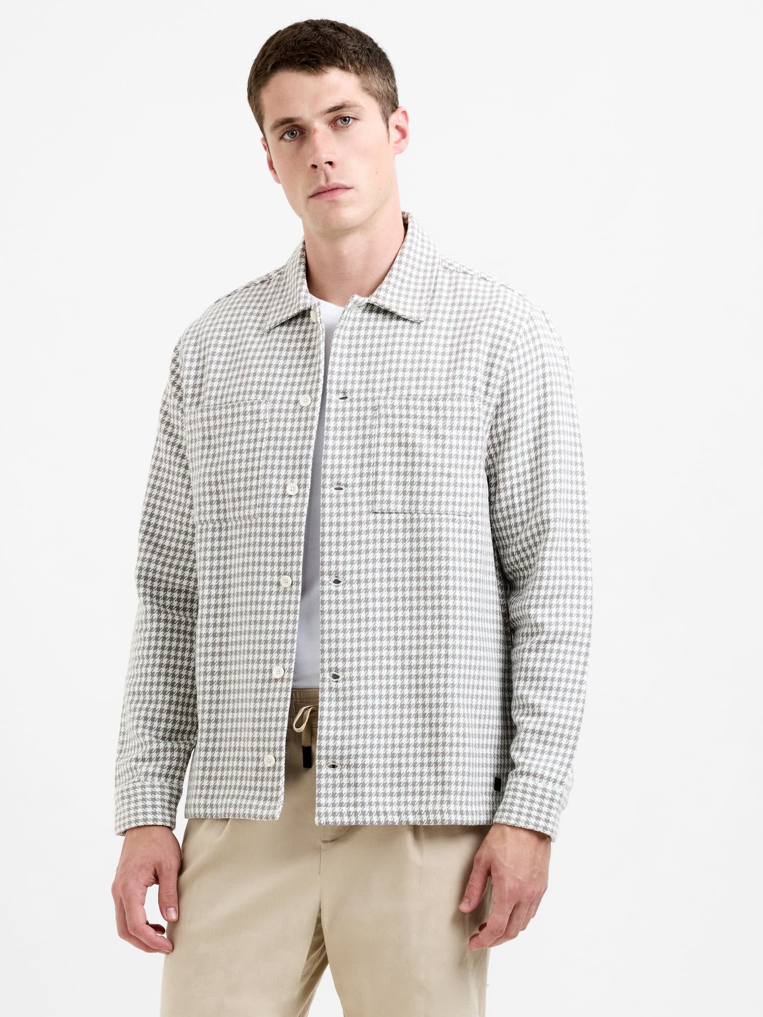 Houndstooth button-through jacket in bone white and fungi colors, featuring a relaxed fit, chest pocket, and a textured fabric.