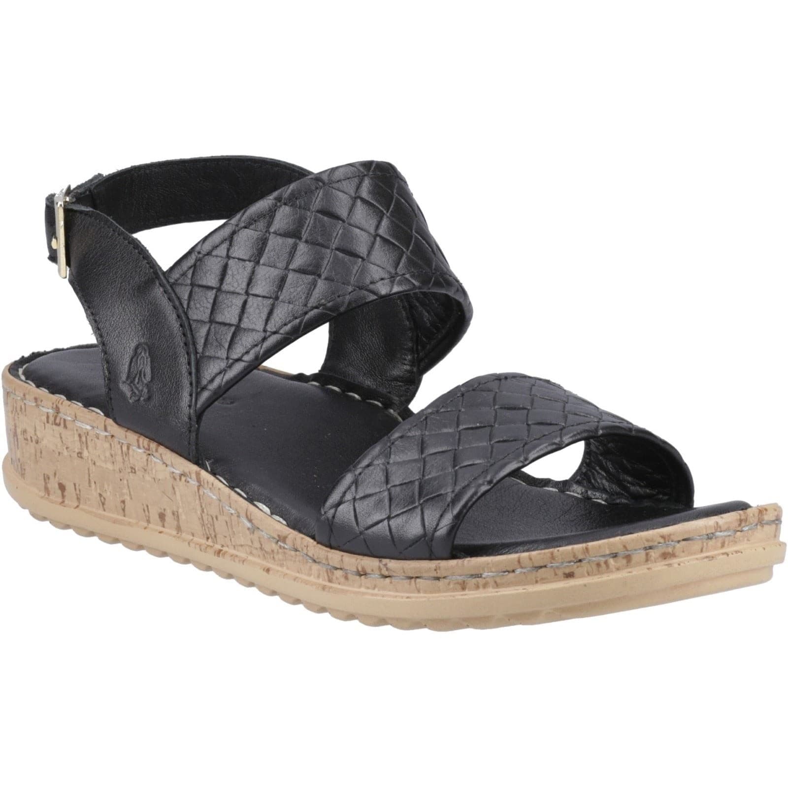 Black woven sandal with cross straps, cork wedge sole, and adjustable ankle strap by Hush Puppies, featuring a textured upper and open toe design.