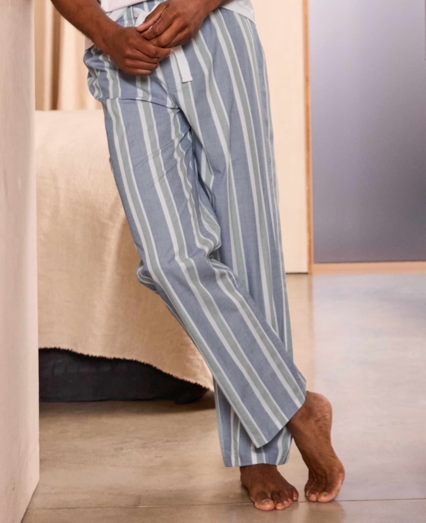Men's lounge pants in blue and green stripes, made of cotton, featuring a relaxed fit and side pockets, displayed in a casual setting. Size: Large.