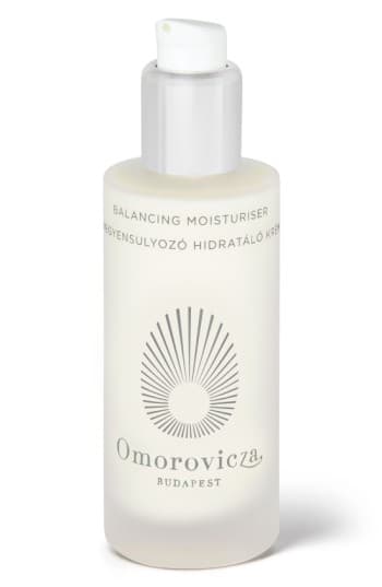Clear glass bottle with a frosted finish, featuring a white pump top, labeled "Balancing Moisturiser" and "Omorovicza Budapest" in elegant black font.