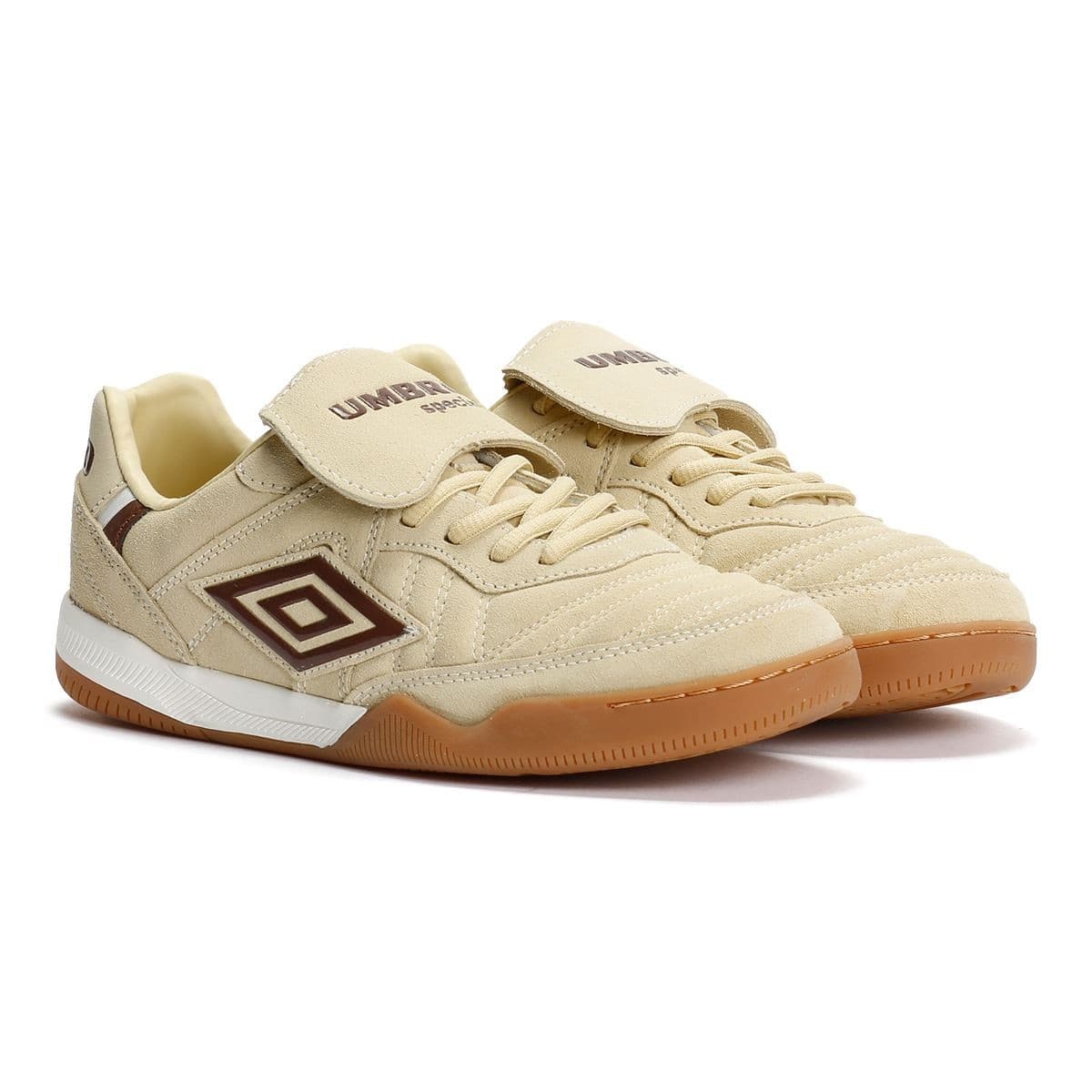 Cream suede trainers with dark brown accents, featuring a Velcro flap, white midsole, and a gum rubber outsole, showcasing a classic sporty design by Umbro.
